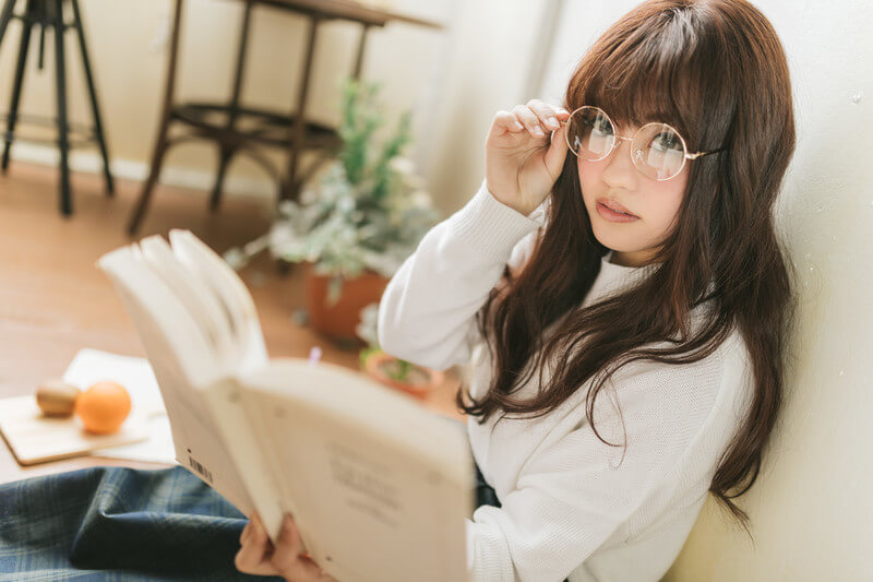 眼鏡をかけて本を読む女性